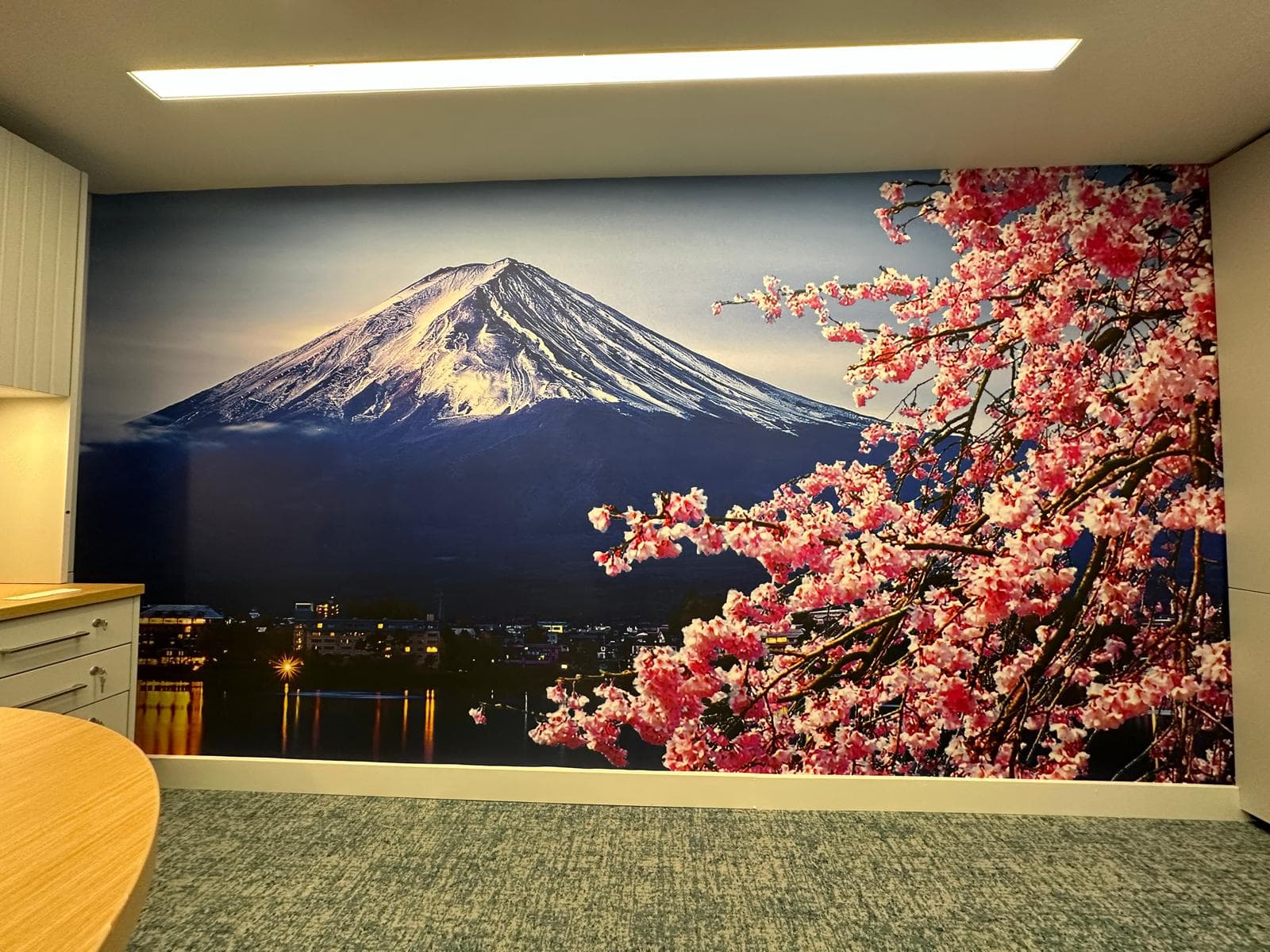 Large-format mountain and cherry blossom mural installed across an interior wall